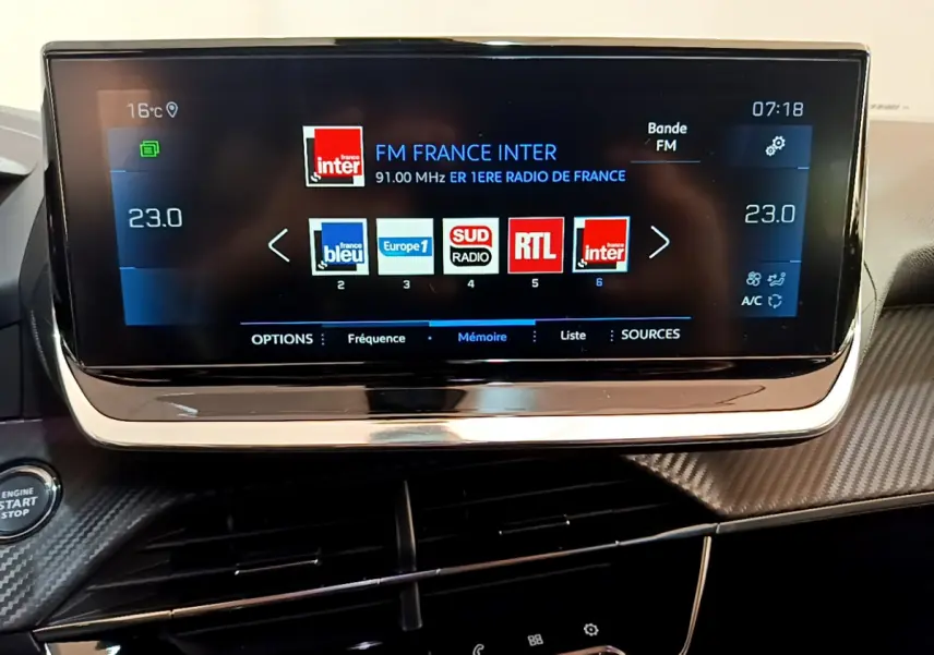 Écran tactile 10 pouces du tableau de bord du Peugeot 2008 gris clair, affichant les stations radio FM.