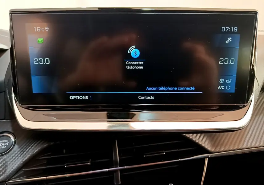 Écran tactile central du tableau de bord du Peugeot 2008 gris clair, affichant la connexion Bluetooth et la climatisation à 23°C.