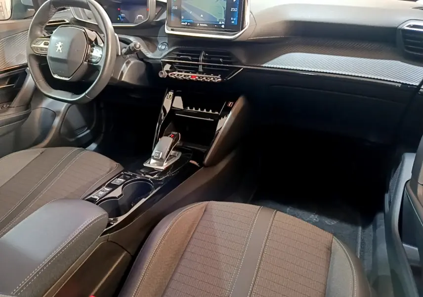 Intérieur du Peugeot 2008 vue côté passager, tableau de bord moderne avec écran tactile et sellerie tissu gris.