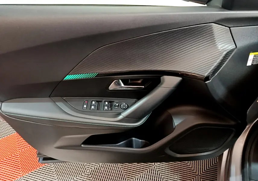 Vue rapprochée de la porte côté conducteur gris clair du Peugeot 2008 avec insert décoratif et commandes électriques.
