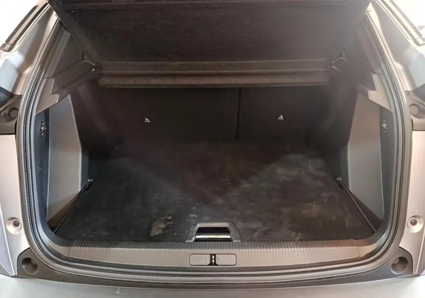 Coffre ouvert gris clair du Peugeot 2008 PureTech 130, vue arrière montrant l'espace de chargement vide.