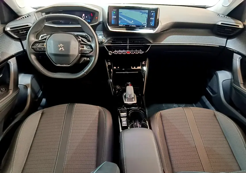 Intérieur Peugeot 2008 gris clair, vue avant centrée sur le volant cuir, tableau de bord numérique et écran tactile 10 pouces.