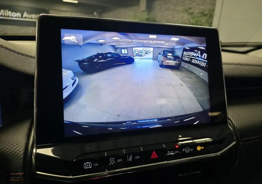Vue de l'écran de caméra de recul affichant l'arrière du Jeep Compass Trailhawk noir en intérieur.