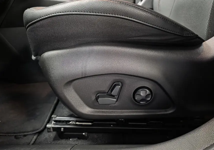 Réglage électrique du siège avant côté gauche sur cuir noir avec surpiqûres rouges du Jeep Compass Trailhawk 2024.