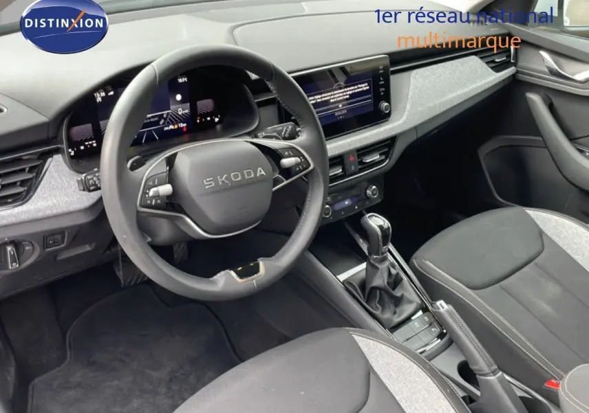Vue intérieure côté conducteur du Skoda Kamiq 2025, volant multifonction et tableau de bord numérique en noir et gris.