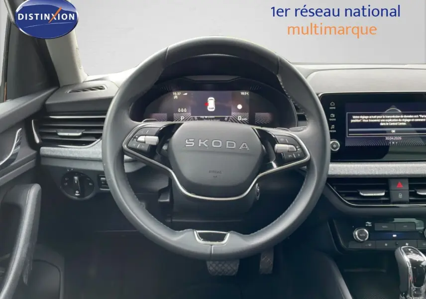 Vue centrée sur le volant noir SKODA du KAMIQ 2025, avec tableau de bord numérique et écran tactile à droite.