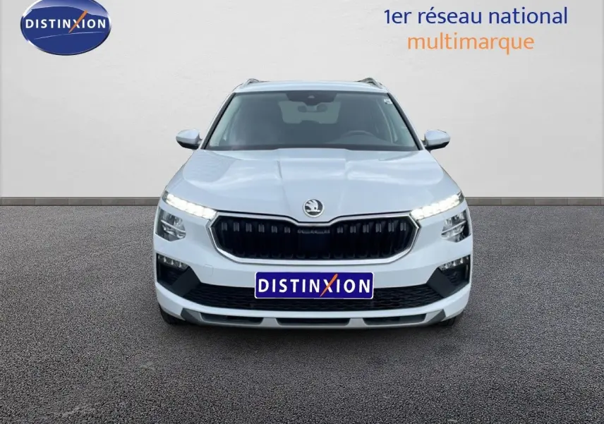 Vue frontale d’un Skoda Kamiq blanc glacier 2025 avec calandre noire et feux LED allumés.