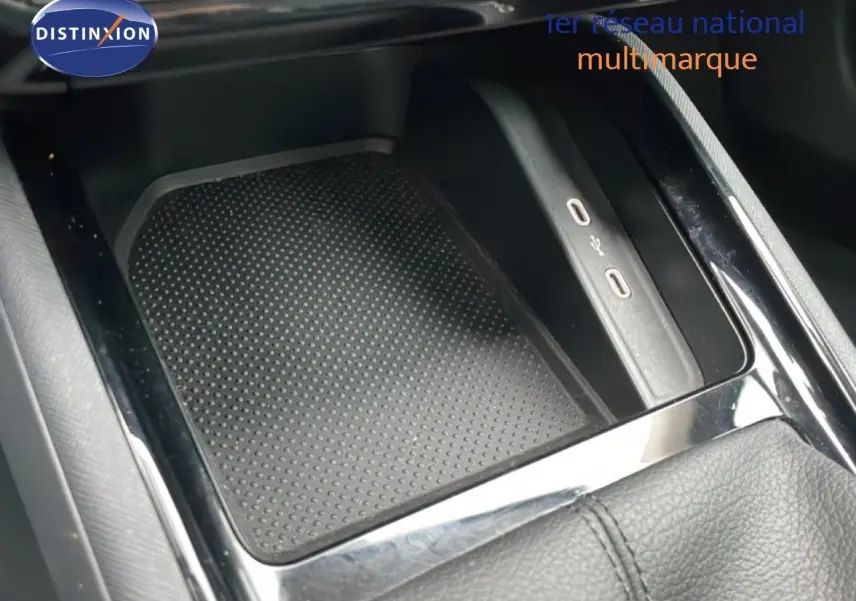 Gros plan sur la console centrale noire du Skoda Kamiq 2025 avec zone de recharge et ports USB visibles.