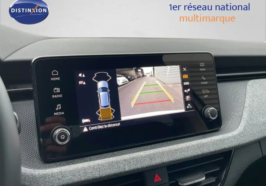 Écran central du Skoda Kamiq blanc glacier 2025 montrant la caméra de recul avec guidage de trajectoire.