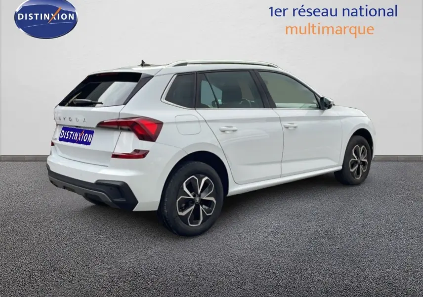 Vue 3/4 arrière droite d'un Skoda Kamiq blanc glacier de 2025 avec jantes noires et feux arrière LED distinctifs.