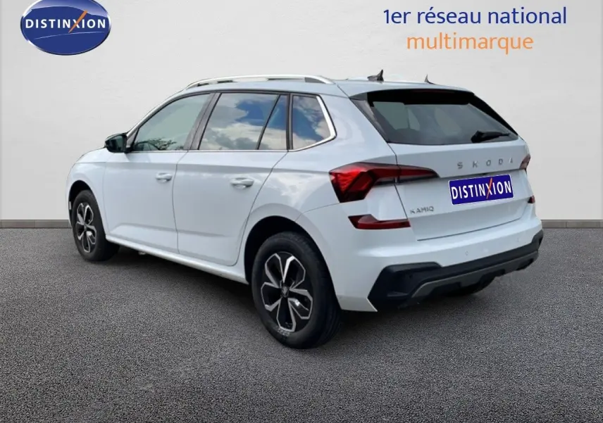 Vue 3/4 arrière droite d'un Skoda Kamiq blanc glacier avec jantes noires et toit ouvrant, sur fond neutre.