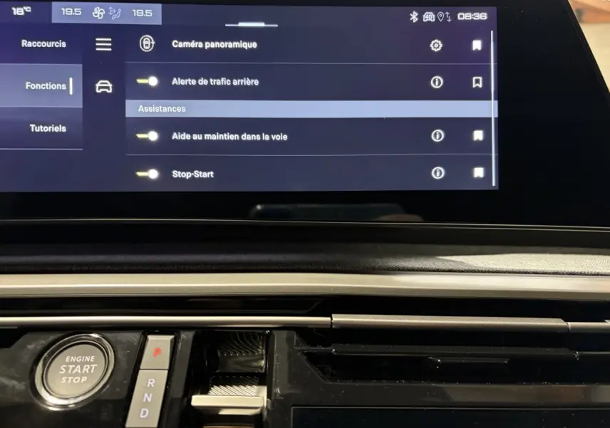 Vue rapprochée du tableau de bord du Peugeot 3008 blanc 2026, avec écran tactile multifonctions et bouton démarrage visible.