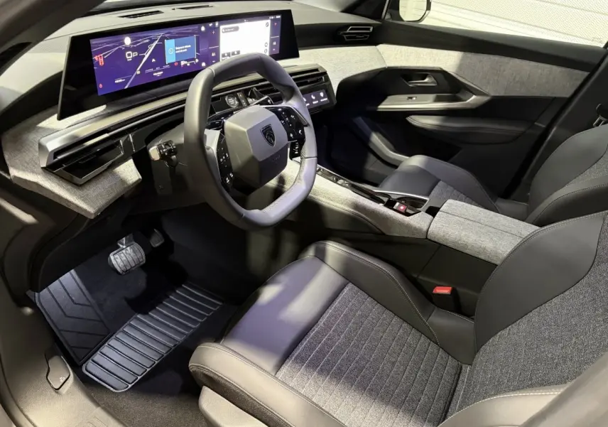 Intérieur Peugeot 3008 hybride 2026 vu côté conducteur, volant compact et grand écran tactile panoramique.
