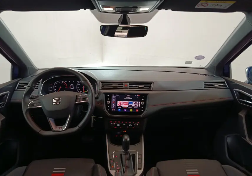 Intérieur du SEAT Arona bleu 2021, vue frontale du tableau de bord avec écran tactile et volant multifonctions.