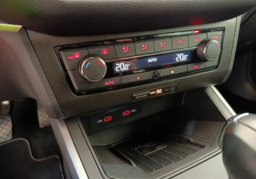 Gros plan sur la console centrale du SEAT Arona 2021, montrant la climatisation digitale et la zone de recharge sans fil.