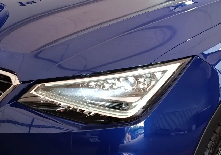 Gros plan sur le phare avant droit LED d'une SEAT ARONA bleu 2021, soulignant son design anguleux moderne.