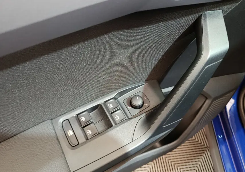 Gros plan sur la commande des vitres et rétroviseurs côté conducteur d'une SEAT Arona bleu 2021.