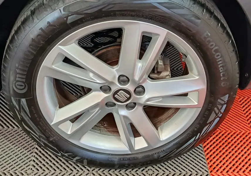 Gros plan sur la jante alliage argentée avec logo SEAT d’un pneu Continental monté sur un SEAT Arona bleu.