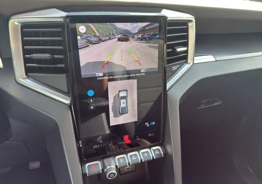 Vue rapprochée de l'écran central tactile du Volkswagen Amarok 2025 gris foncé, affichant la caméra de recul et les commandes.