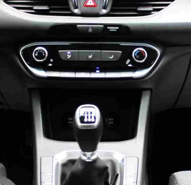 Intérieur de la Hyundai i30 SW 2022 montrant la console centrale avec levier de vitesse manuel et écran tactile.