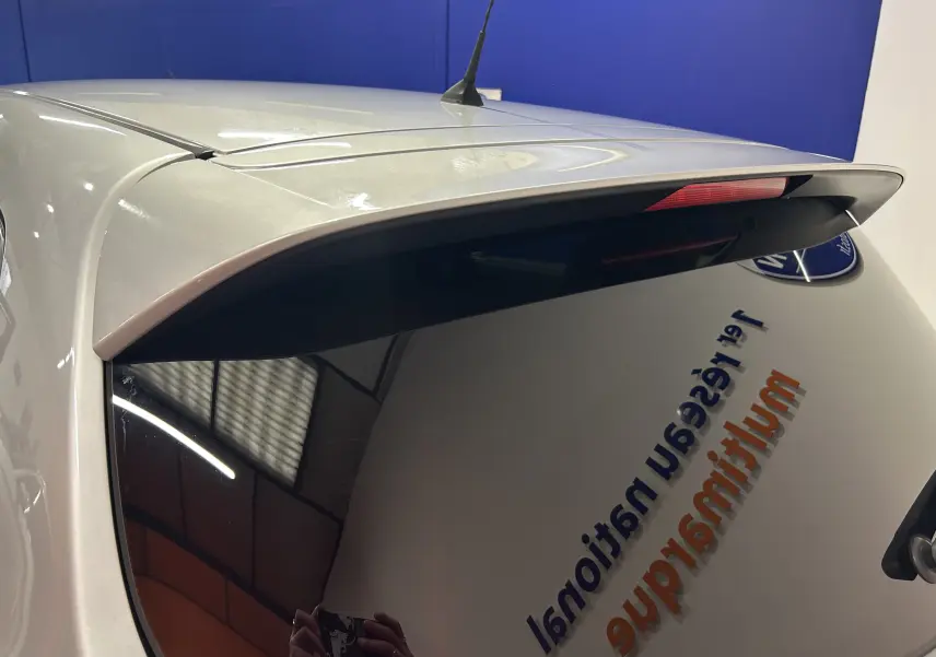 Vue arrière en léger angle d'une Nissan Pulsar gris métallisé avec vitre arrière teintée et aileron intégré.