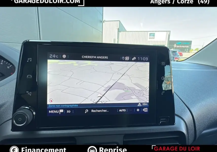 Vue intérieure du tableau de bord du Peugeot Rifter 2024 avec écran tactile de navigation allumé.