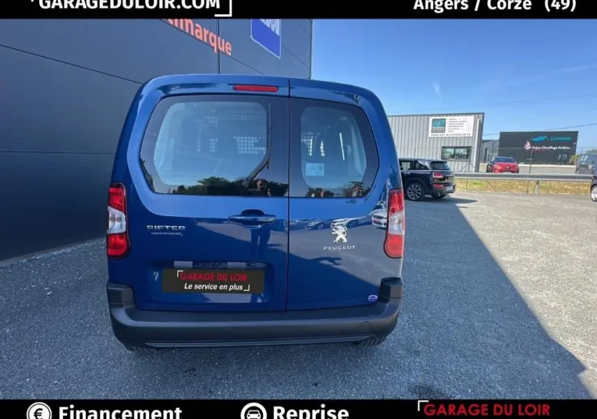 Vue arrière d’un Peugeot Rifter bleu 2024, version 1.5 BlueHDi, avec portes battantes et logo visible.