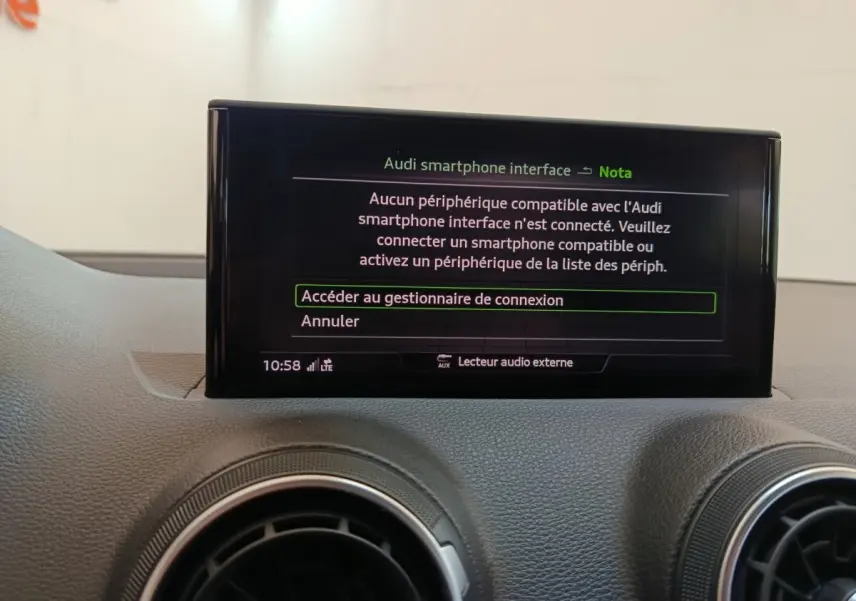 Écran tactile central affichant l'interface smartphone Audi dans l'habitacle gris foncé de l'Audi Q2 35 TFSI Business Line.