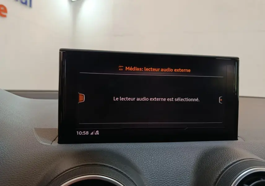 Écran tactile central affichant la sélection du lecteur audio externe dans l'Audi Q2, vue intérieure frontale.