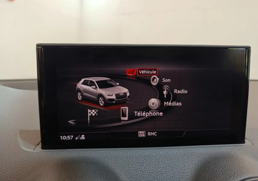 Écran tactile intérieur affichant le menu multimédia avec une Audi Q2 grise vue de profil droit en illustration.