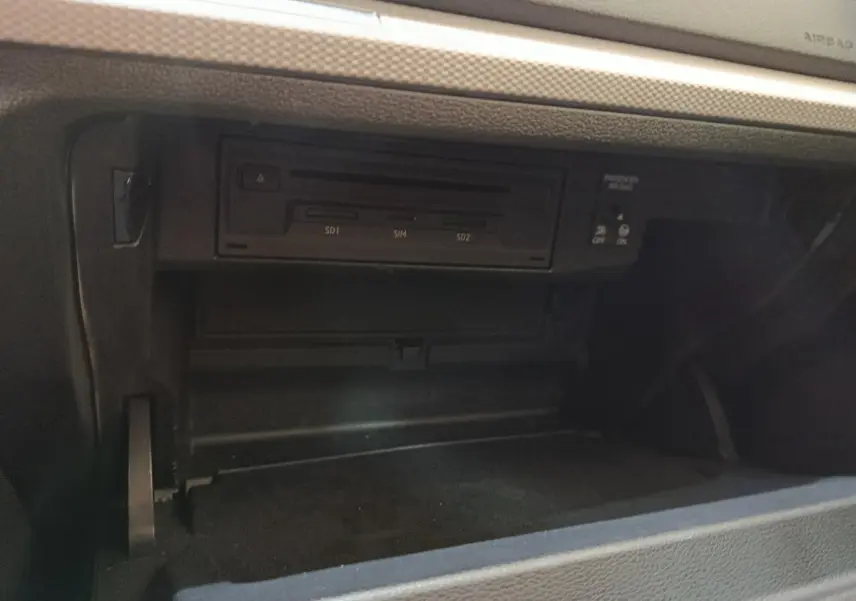 Gros plan sur la boîte à gants ouverte de l'Audi Q2 35 TFSI 150 S Tronic Business Line 2022, intérieur noir.