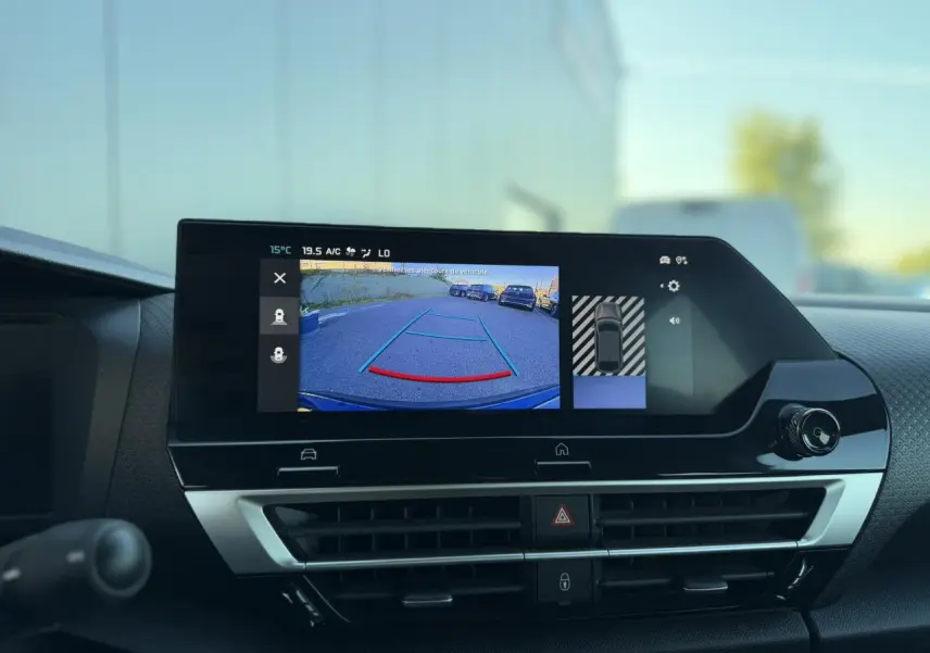 Vue intérieure du tableau de bord de la Citroën C4 Hybrid 145, écran tactile affichant la caméra de recul et la navigation.