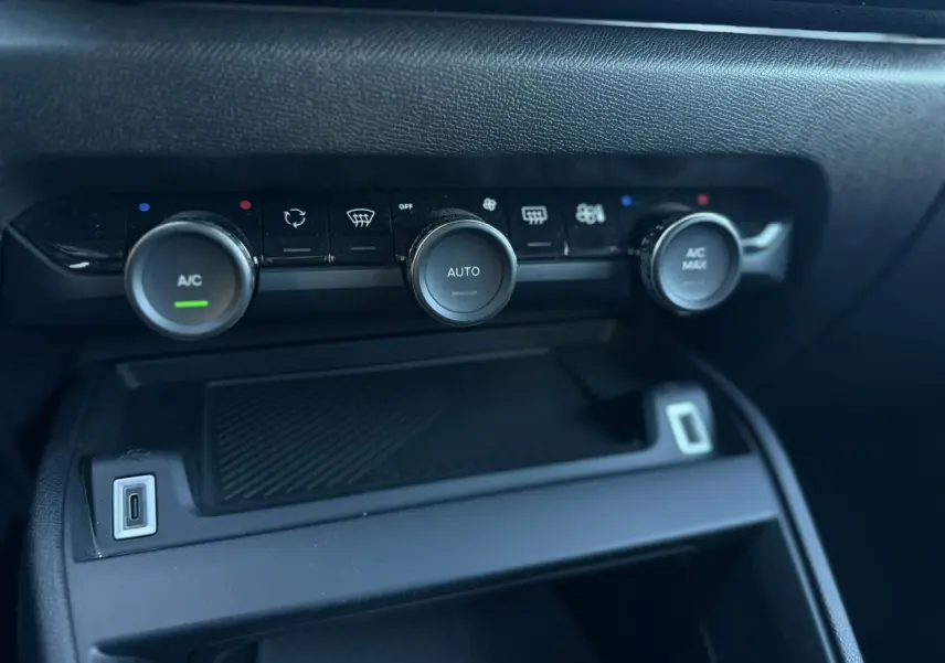 Gros plan sur la console centrale de la Citroën C4 Hybrid 145 e-DSC6 Plus, montrant les commandes de climatisation automatique.