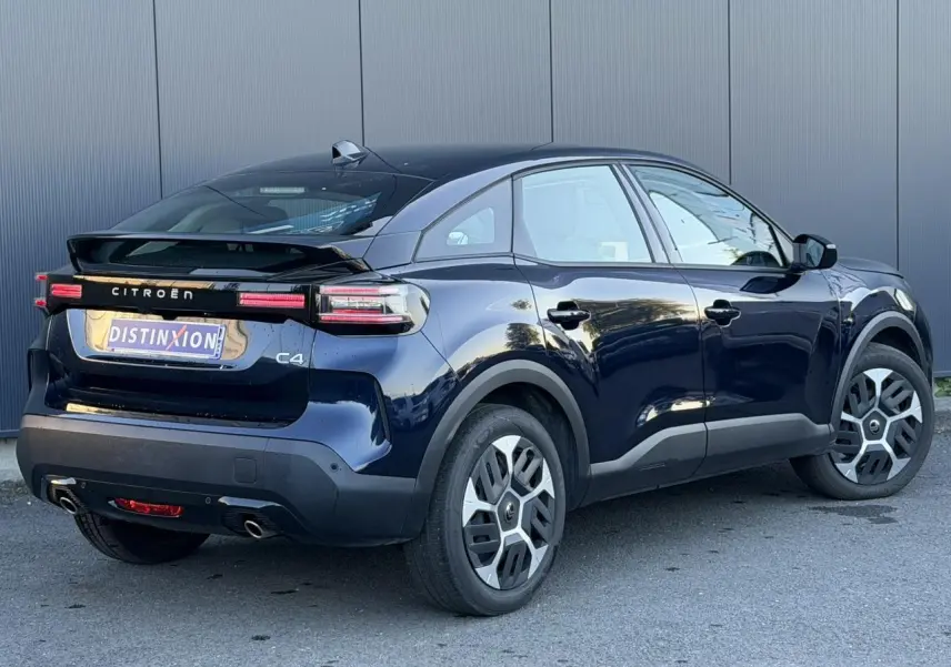 Vue 3/4 arrière droite d'une Citroën C4 Hybrid 145 bleu Eclipse avec feux arrière LED et jantes spécifiques.