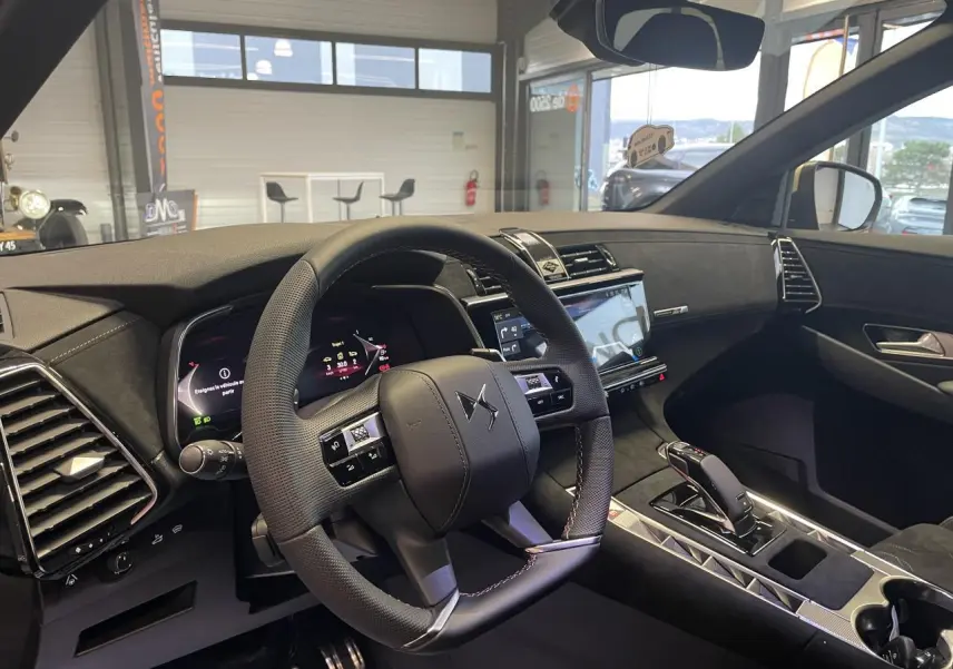 Vue intérieure côté conducteur du DS7 Crossback 2026 avec volant cuir perforé et tableau de bord Alcantara noir profond.
