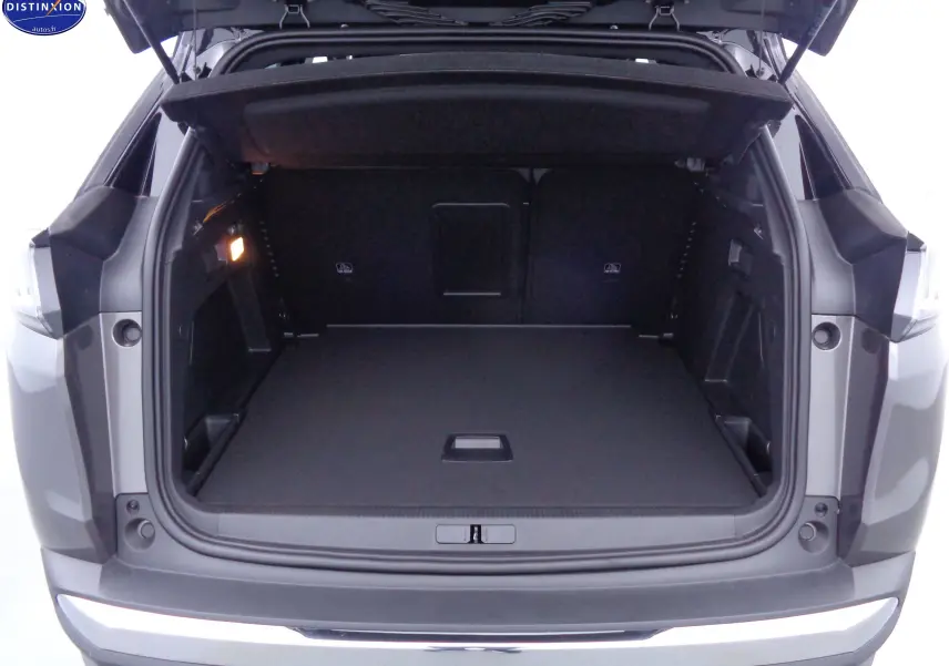 Coffre ouvert du Peugeot 3008 gris platinium métal, vue arrière montrant un espace de chargement spacieux et bien fini.