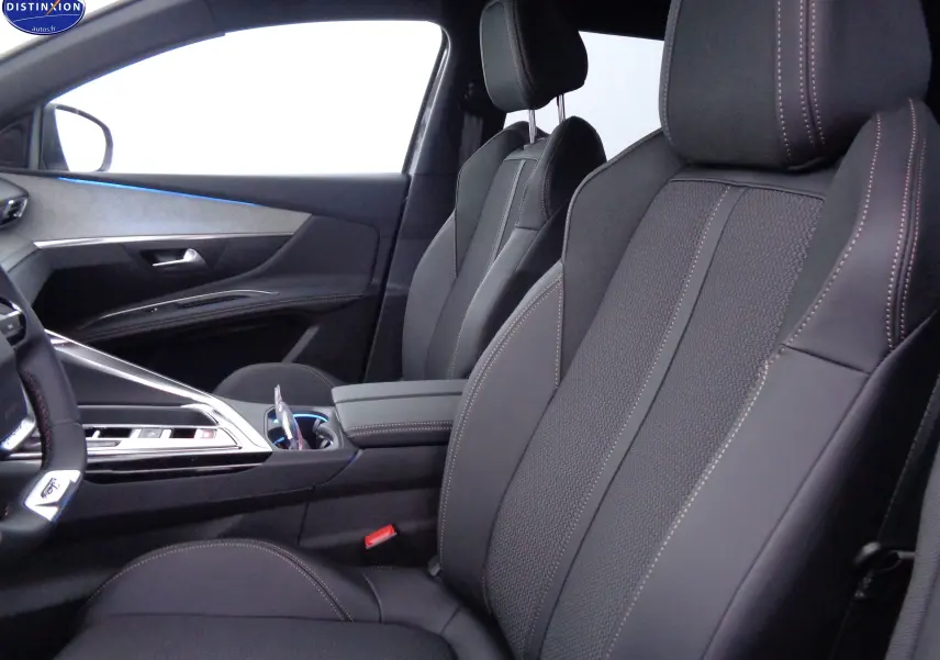 Intérieur avant droit du Peugeot 3008 2023, sièges en cuir noir avec surpiqûres contrastées et console centrale moderne.