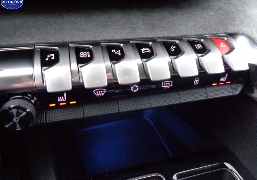 Gros plan sur les commandes piano du tableau de bord du Peugeot 3008 gris platinium, avec éclairage rouge des sièges chauffants.