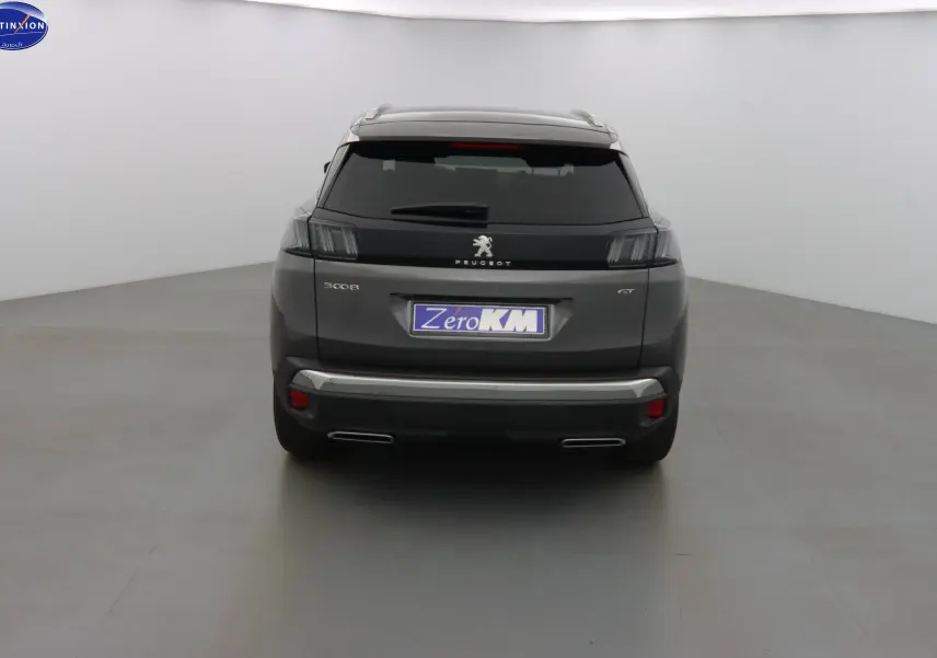 Vue arrière du Peugeot 3008 GT gris platinium métal 2023 avec feux sombres et double sortie d’échappement.