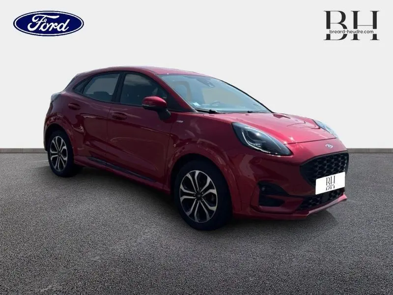 Ford Puma 2022 rouge métallisé en 3/4 avant droit avec jantes alu et calandre noire distinctive.
