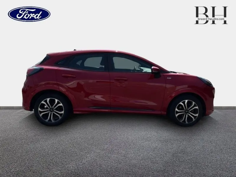 Profil droit d'un Ford Puma 2022 rouge métallisé avec jantes alliage et lignes sportives marquées.