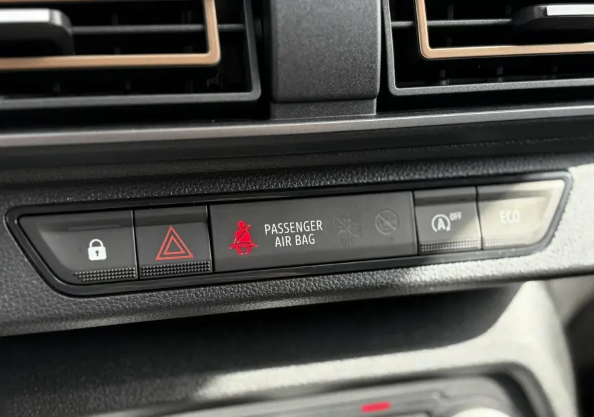 Gros plan sur la console centrale du Dacia Jogger gris, montrant les voyants de sécurité et mode ECO.