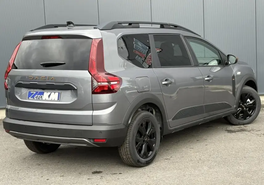 Vue 3/4 arrière droite du Dacia Jogger gris schiste avec jantes noires et vitres arrière surteintées.