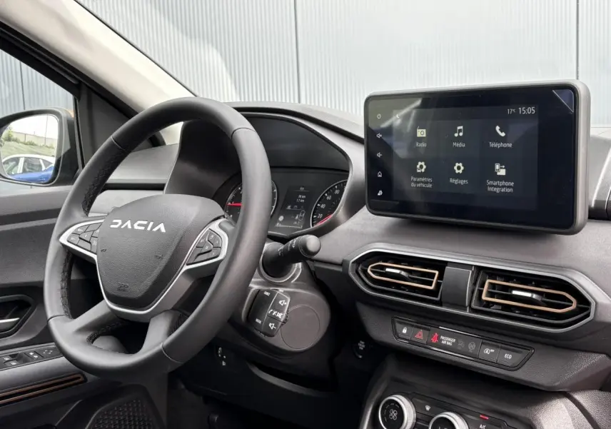 Intérieur du Dacia Jogger 2025 vu côté gauche, volant noir, écran tactile central et aérateurs hexagonaux.