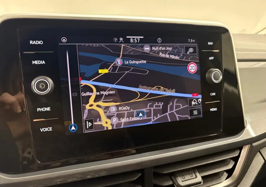 Écran tactile central du Volkswagen T-Roc bleu pétrole, affichant la navigation avec carte et commandes autour.