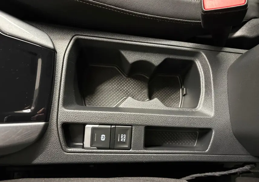 Gros plan sur la console centrale du Volkswagen T-Roc 1.5 TSI 150 DSG7 Style Edition avec porte-gobelets et commandes électroniques.