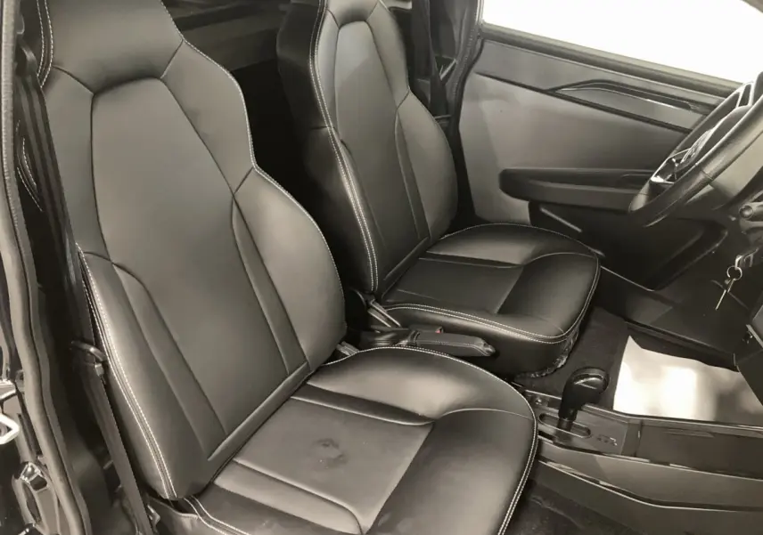 Vue intérieure côté conducteur du Ligier JS50 0.5 REVO D+ Select noir, sièges confort en cuir avec surpiqûres blanches.