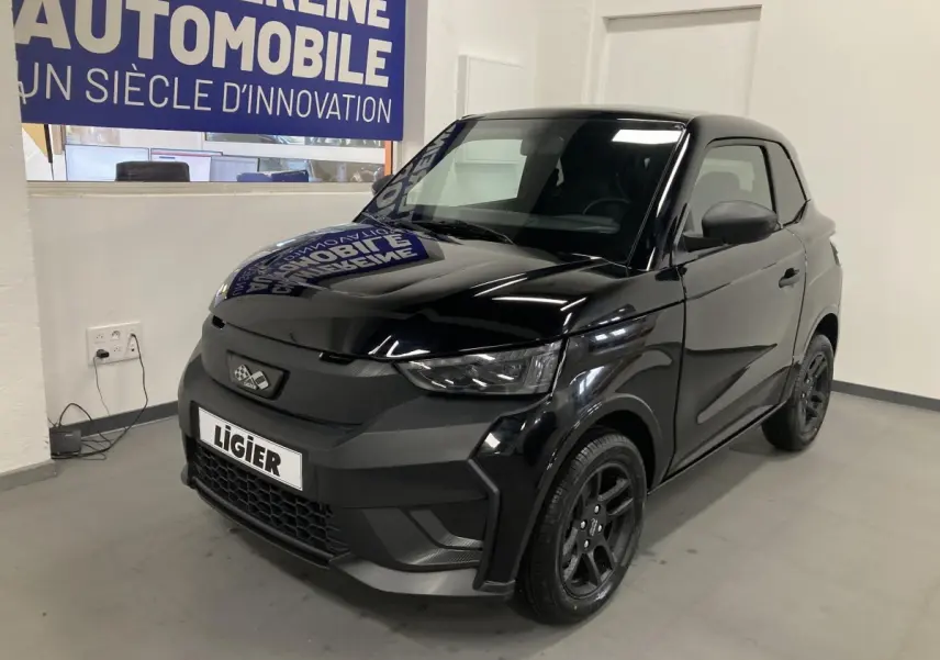 LIGIER JS50 0.5 REVO D+ noir vue 3/4 avant droit avec jantes alu noires et feux LED en intérieur showroom.