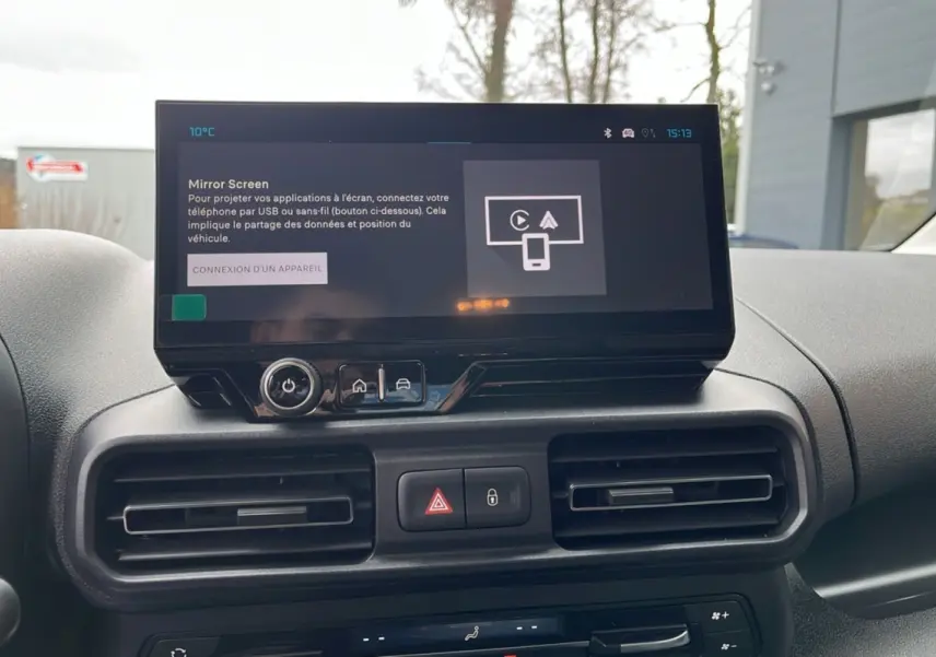 Vue frontale du tableau de bord du Citroën Berlingo blanc avec écran tactile central et commandes de climatisation.