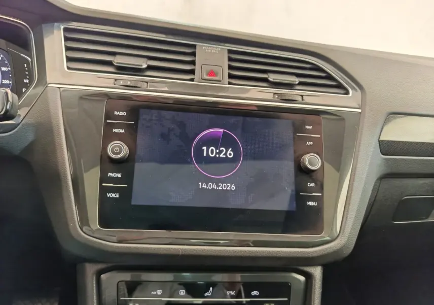 Vue intérieure centrée sur l’écran tactile et la console de climatisation du Volkswagen Tiguan 2022, finition élégante noire.